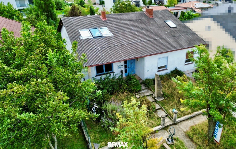 Haus - 7132, Frauenkirchen - Ort der Kreativität - Ein Haus umgeben von Sandstein und viel Grün.